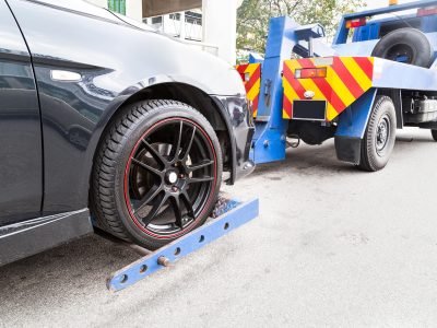 tow-truck-towing-a-broken-down-car-on-the-street-P46CHJA.jpg