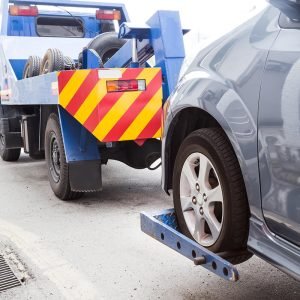 tow-truck-towing-a-broken-down-car-on-the-street-PE9HH3A